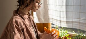 A Person Who Is Fighting A Craving For Alcohol Peels An Orange